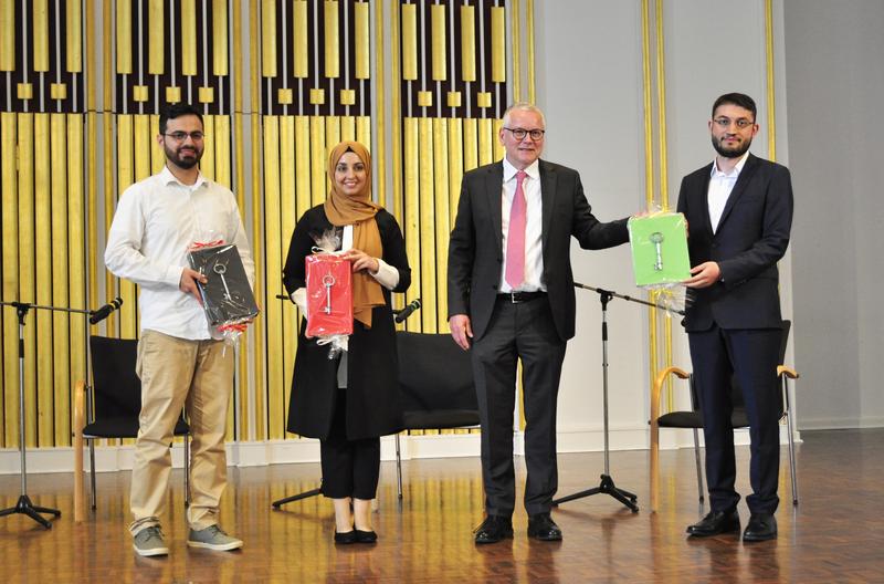 Theologinnen und Theologen konnten sich in der Gefängnisseelsorge ausbilden zu lassen. Staatssekretär Dr. Frank-Thomas Hett (3.v.l.) überreichte den künftigen Seelsorgern Enes Erdogan, Sümeyra Yavas und Cengiz Ayar symbolisch einen Gefängnisschlüssel.