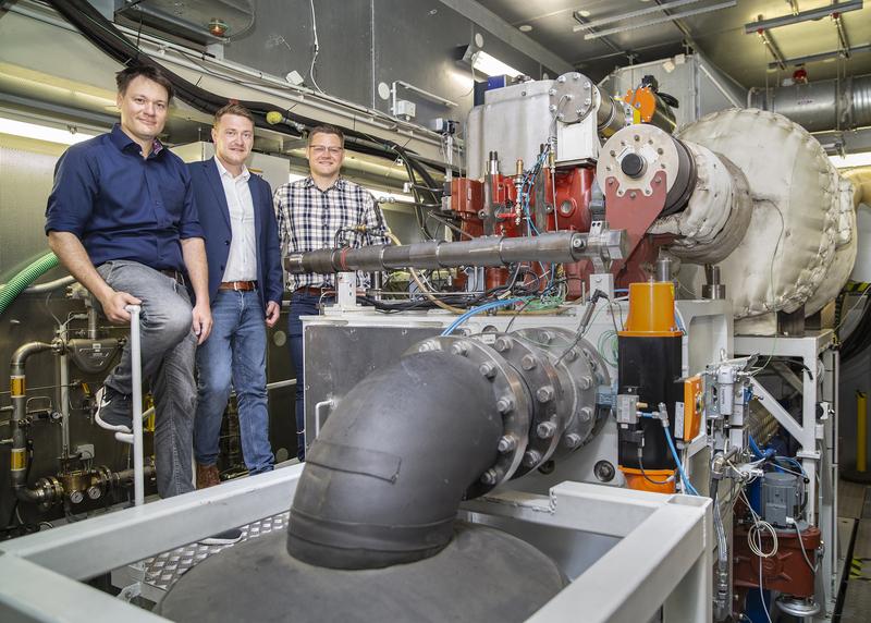 v.l.: Die drei experimentell arbeitenden Motorenforscher Karsten Schleef, Sebastian Cepelak, Björn Henke (Alle frisch und negativ auf Corona getestet.) vor dem Einzylinder-Forschungsmotor des Lehrstuhls für Kolbenmaschinen und Verbrennungsmotoren.