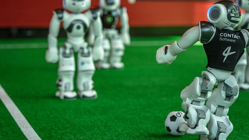 Die NAOs von B-Human passen sich bei der RoboCup 2021 Worldwide den Ball zu 