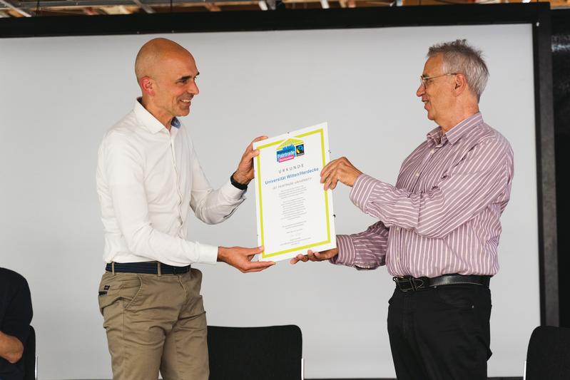 Dieter Overath, geschäftsführender Vorstand von Fairtrade Deutschland (rechts im Bild) übergibt Vizepräsident Dirk Jakobs die Urkunde.