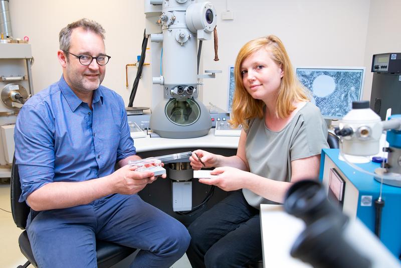 Dr. Julia Schipke und Professor Christian Mühlfeld vor einem Elektronenmikroskop.