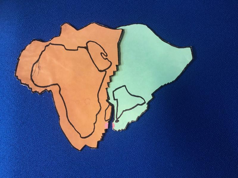 Ein Vulkan (roter Punkt) spreizt die Indische und Afrikanische Platte. Im Norden löst die Gegenbewegung Subduktionsprozesse aus: Indien taucht unter Afrika. Erdbeben entstehen.