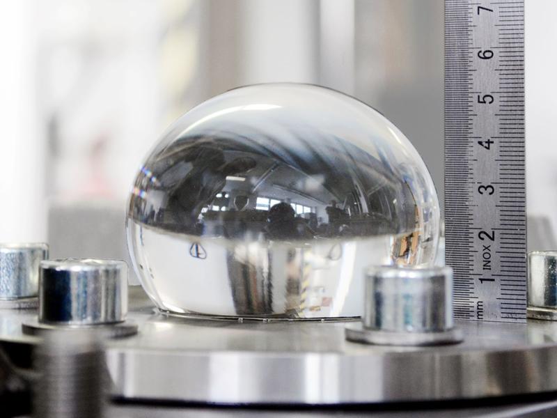 Inflated test specimen without black and white pattern, applying the circular ring with the diameter Ø50 mm. The ruler is used for visual control of the bubble height during the test.