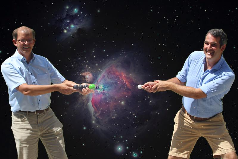 Die Physiker Roland Wester (li.) und Malcolm Simpson (re.) demonstrieren, wie Dipol-gebundene Zustände die Entstehung negativer Ionen in interstellaren Wolken ermöglichen. 