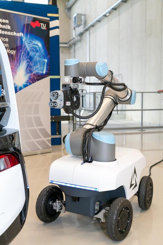 The automated robot arm guides the charging cable to the vehicle's charging socket with millimetre precision and is mounted on an autonomously navigating mobile platform.