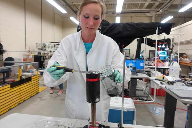 Geomicrobiologist Judith Klatt, formerly at the University of Michigan and now at the Max Planck Institute for Marine Microbiology, scrapes a microbial mat from the top of a sediment core collected at the Middle Island Sinkhole in Lake Huron.