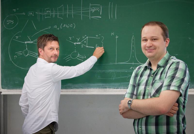 Datenanalyse: Prof. Dr. Bernhard Ketzer (links) und Mathias Wagner (rechts) erläutern einen speziellen Prozess bei der Streuung von hochenergetischen Pionen an Protonen, die sogenannte Dreieckssingularität. 