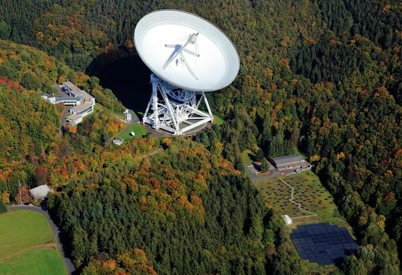 Aerial view, showing the Effelsberg radio observatory with two telescopes, the 100-m parabolic dish (top center) and the Effelsberg LOFAR station (bottom right).