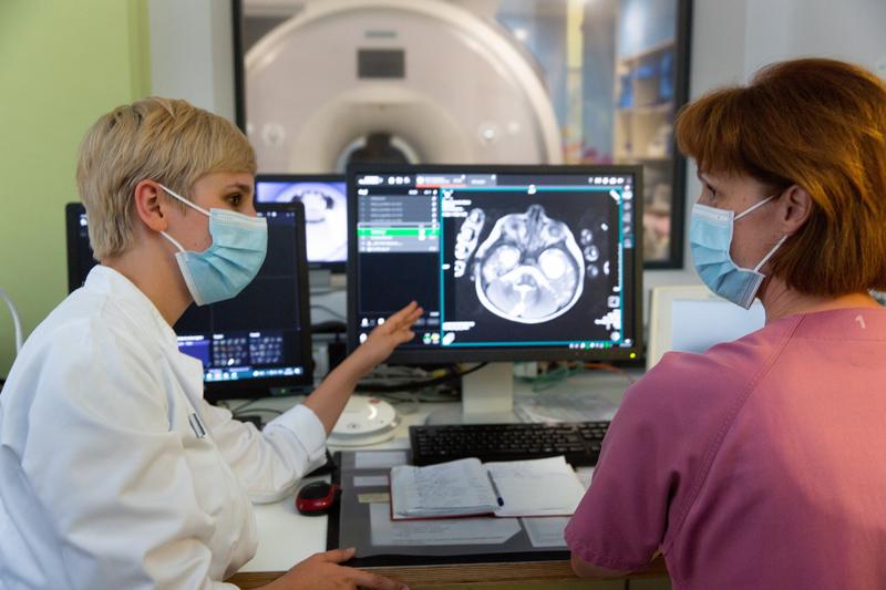 Dr. Rebecca Anders (li). Und MTRA Anke Späthe besprechen die Bilder, die sie praktisch in Echtzeit auf ihrem Monitor sehen. Im Hintergrund die Röhre des MRT.