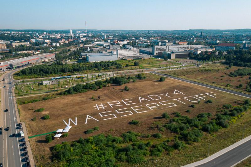 Auf dem künftigen Gelände des „Hydrogen and Mobility Innovation Center“ in unmittelbarer Nähe der TU Chemnitz verkünden riesige Stoffbanner die Botschaft: Chemnitz ist #Ready4Wasserstoff. 