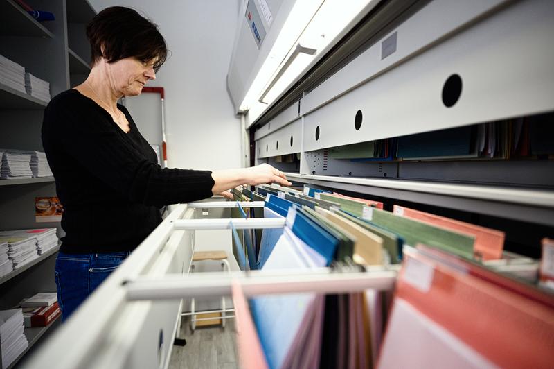 Christine Jacob aus dem Studienbüro der Hochschule Coburg zeigt den Pater Noster für Akten im Studienbüro der Hochschule Coburg: Er wird immer leerer. Foto: Julian Uebe / Hochschule Coburg