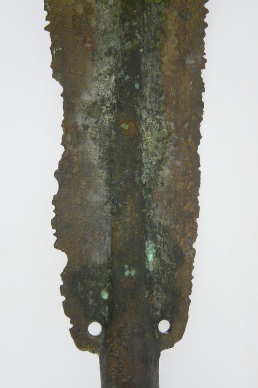 Blatt einer bronzenen Lanzenspitze mit intentional zerstörten Schneiden. Das Stück gelangte aus Sizilien nach Olympia. 