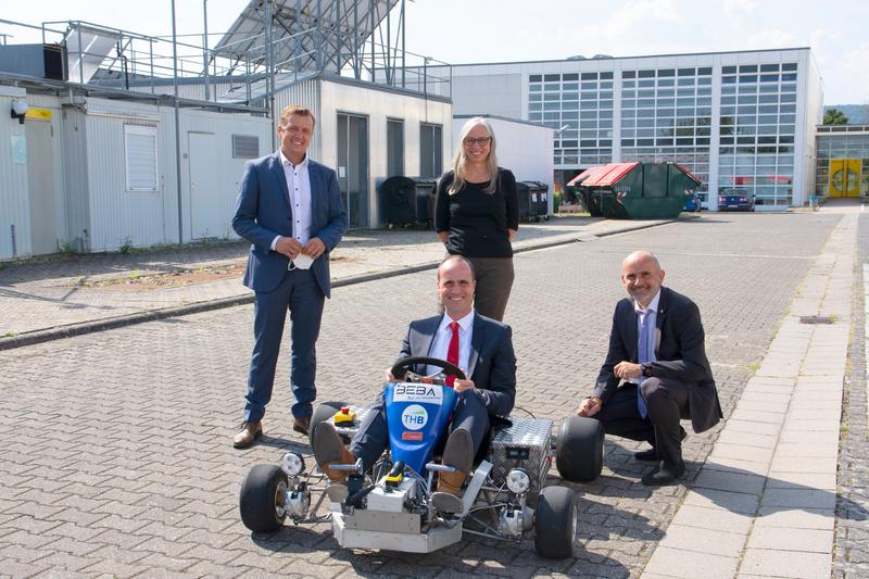 Prof. Dr. Jens Passek, Professor für Fahrzeugbau, die zukünftige TH-Präsidentin Prof. Dr. Antje Krause und der amtierende Präsident Prof. Dr. Klaus Becker (hinten, v. l. n. r.) freuen sich über den Besuch des Ministers Clemens Hoch.