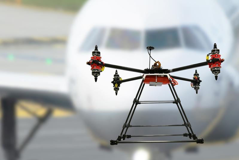 Symbolfoto: Drohne vor einem Passagierflugzeug (Montage)
