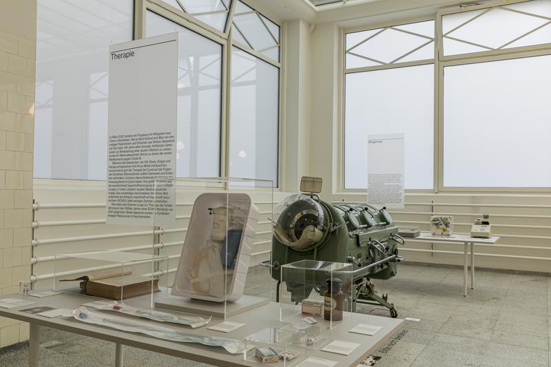 In der Ausstellung ist eine Eiserne Lunge neben einem modernen ECMO-Filter zu sehen. Beide symbolisierten in ihrer Zeit medizinischen Fortschritt und Ressourcenknappheit