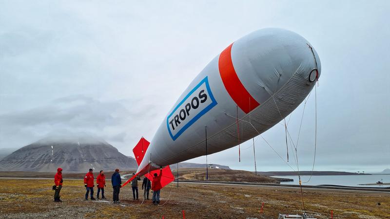 BELUGA kurz vor dem Start mit Blick auf den Kongsfjord und wolkenverhangenen Bergen. 