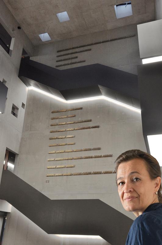 Monika Supé vor dem Kunstwerk, das sechs auf zehn Meter hoch im viergeschossigen Foyer des neuen ITMZ der Hochschule Coburg angebracht wurde. Porträt: Wolfgang Feßlmeier, Fotomontage: Monika Supé
