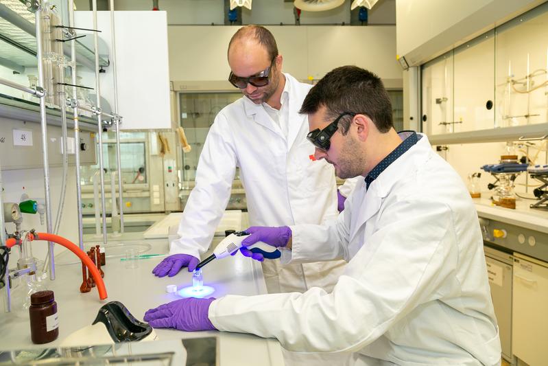 Michael Haas (links) und der Doktorand Manfred Drusgala demonstrieren die Aushärtung einer Kunststoffpaste mittels einer herkömmlichen Zahnarztlampe - dank des germaniumbasierten Photoinitiators funktioniert das ohne UV-Licht.