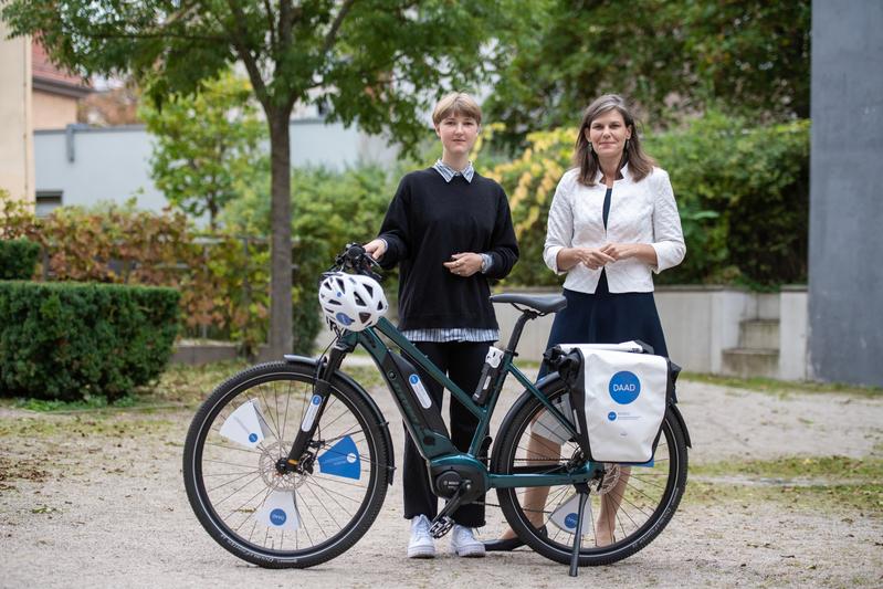 DAAD-Vizepräsidentin Dr. Muriel Helbig (r.) überreicht Carmen Draxler, der 111.111. PROMOS-Geförderten, ein E-Bike.