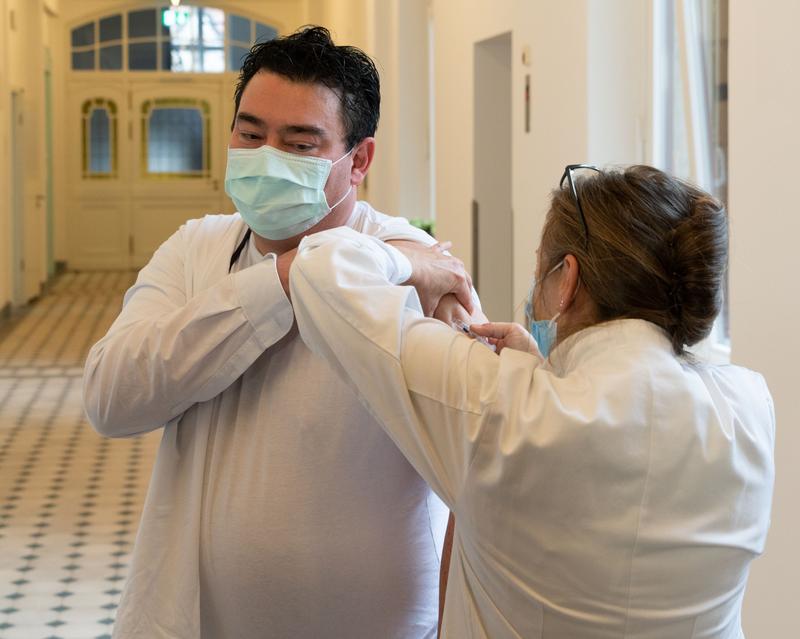 Der Kaufmännische Vorstand des Dresdner Uniklinikums erhält von Susanne Liebe, Leiterin des Betriebsärztlichen Dienstes am Uniklinikum, die Influenza-Impfung.