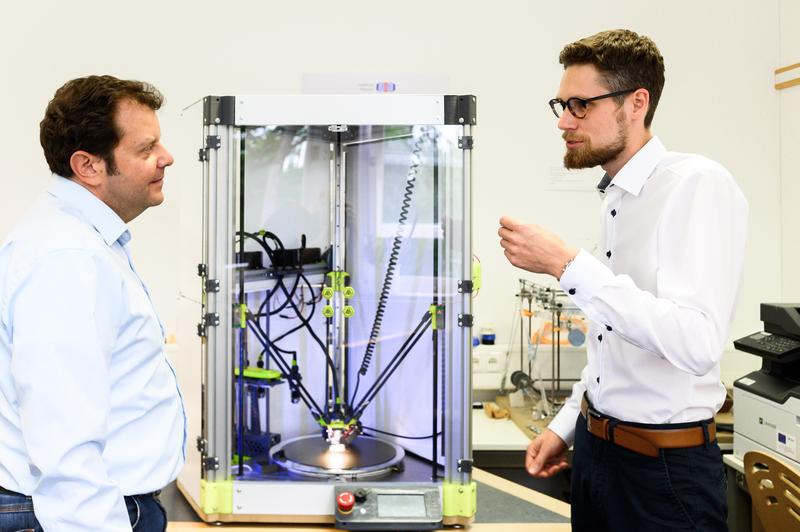 3D-Druck ist an der Hochschule Coburg in vielen Bereichen Thema: Bei Prof. Dr. Markus Stark (links) hat beispielsweise Adrian Beetz (rechts) in seiner Masterarbeit diesen innovativen 3D-Drucker entwickelt. Als Absolvent hat er die Firma AB-3D gegründet.