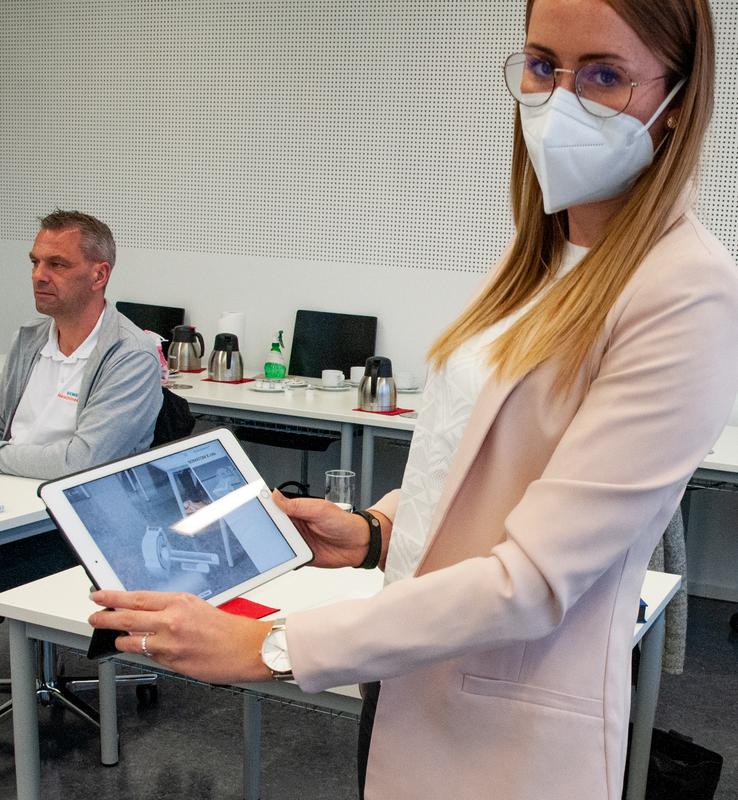 Anna Fuchs, Portfoliomanagerin von Siemens Healtineers zeigt auf dem Tablet, wie Mixed-Reality einen Computertomographen in den Besprechungsraum der Hochschule bringt.