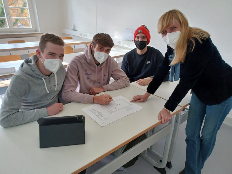 Studiengangleiterin Prof. Dr. Jana Bochert bespricht mit (von links) Patrick Seel, Maximilian Gottschall und Shayan Thiele das Projekt.