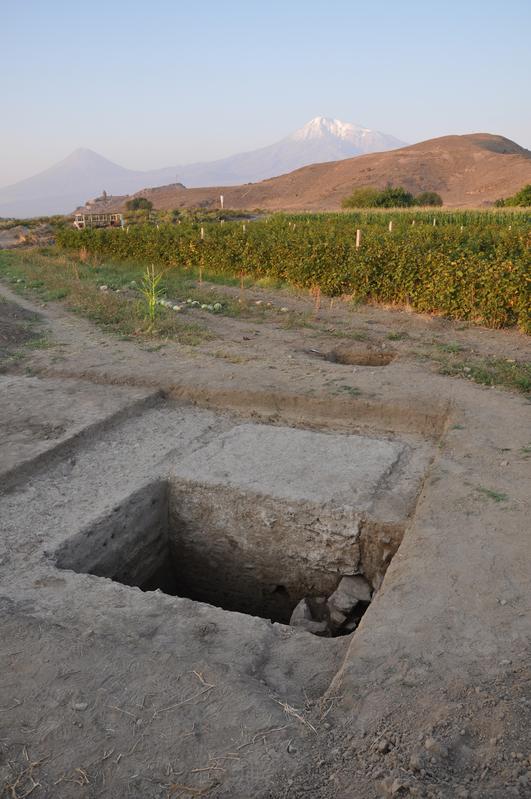 In the background of the excavation area is the hillock in Artaxata on which is located the Khor Virap monastery, with Mount Ararat behind it.