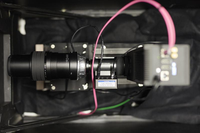 Kamera mit Bildverstärker und Zoom-Objektiv. Das pinkfarbene Kabel schickt bis zu 80 Millionen aktivierter Pixel pro Sekunde zur Datenauswertung an einen Hochleistungs-PC. 