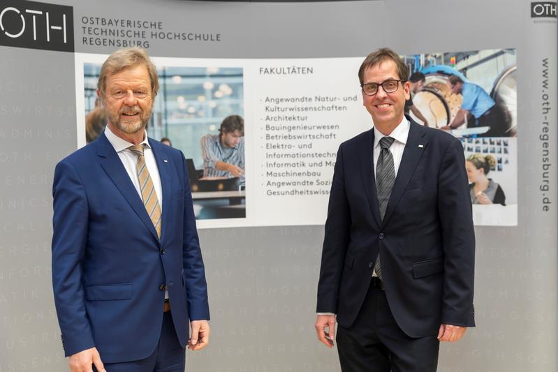 Prof. Dr. Wolfgang Baier, Präsident der OTH Regensburg (links), gratuliert seinem Nachfolger im Amt, Prof. Dr. Ralph Schneider (rechts). 