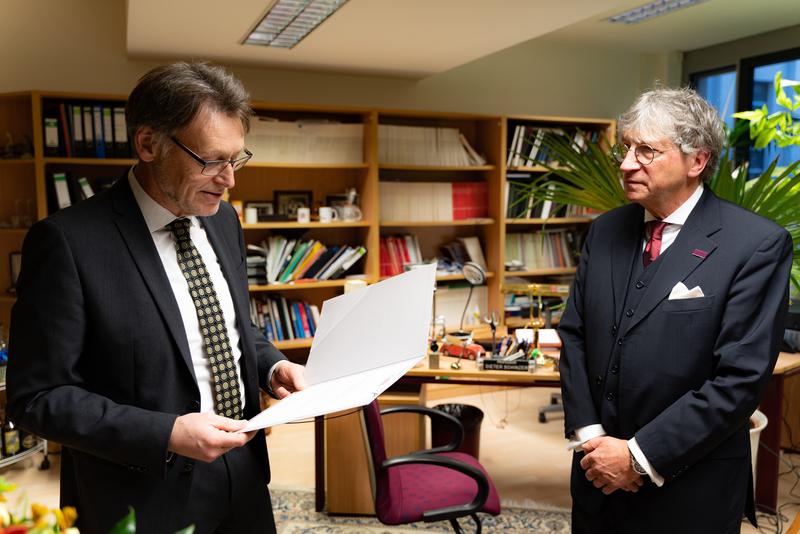 Rektor Prof. Dr.-Ing. Jens Strackeljan (li.) überreicht an Prof. Dr. Dieter Schinzer (re.) die Urkunde zur Verleihung des Otto-von-Guericke-Forschungspreises 2021. 