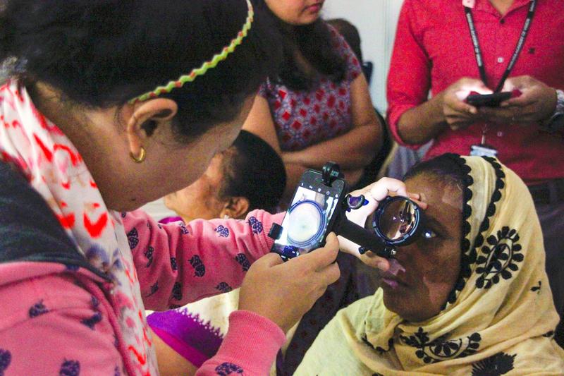 Smartphone-basiertes, telemedizinisches DR-Screening-Programm in Indien: Geschulte augenärztliche Hilfskraft nutzt ein umgerüstetes Smartphone als Augenspiegel.