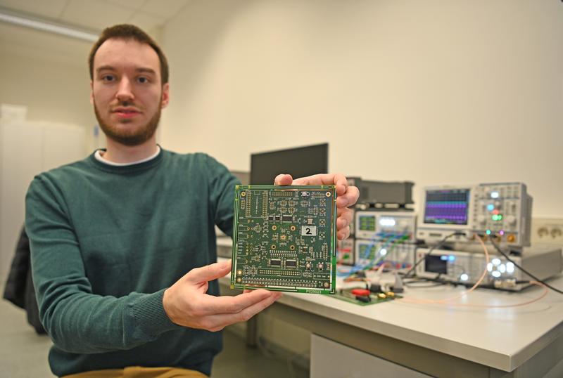 FH-Doktorand Alexander Walsemann präsentiert den neuartigen Chip, der mitten auf einer Platine platziert ist.