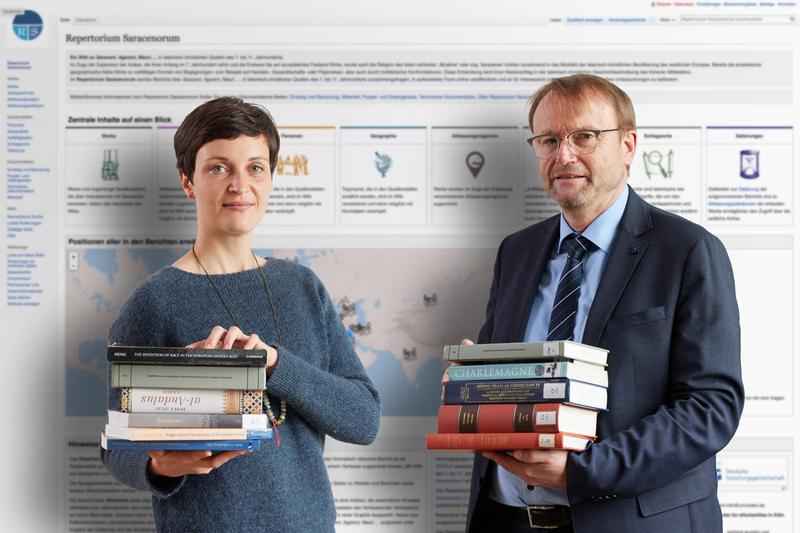 Mit dem Wiki ins Frühmittelalter: Dr. Katharina Gahbler und Prof. Dr. Matthias Becher vom Institut für Geschichtswissenschaft der Uni Bonn vor der groß projizierten Startseite des „Repertorium Saracenorum“.