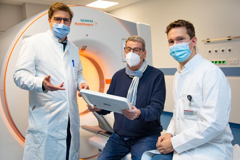 Professor Dr. Jens Vogel-Claussen, patient Gerhard Lunow and Dr. Benjamin Bollmann in front of the CT scanner in the HANSE study truck.
