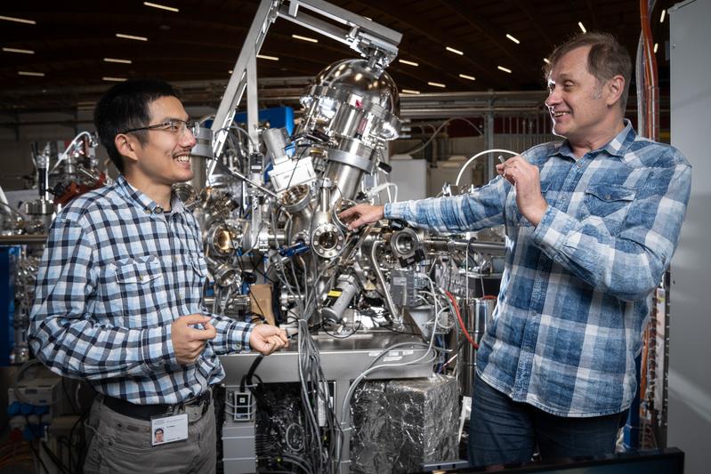 Tianlun Yu (links) und Vladimir Strocov an der ADRESS-Strahllinie der Synchrotron Lichtquelle Schweiz SLS, an der sie die Schichtstruktur aus dem Halbleiter Galliumnitrid und dem Supraleiter Niobnitrid vermessen haben.