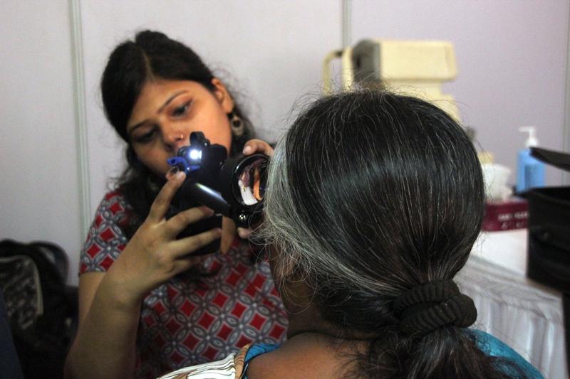Smartphone-basiertes, telemedizinisches Screening-Programm in Indien: Eine geschulte augenärztliche Hilfskraft nutzt ein umgerüstetes Smartphone als Augenspiegel. 