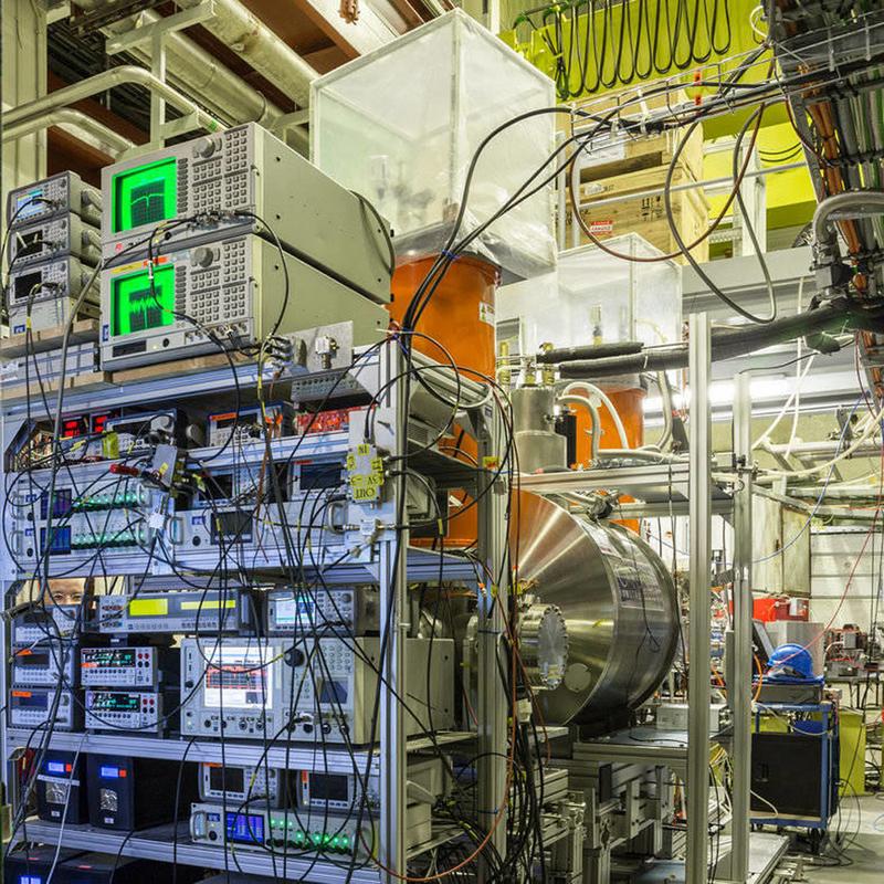 The BASE experiment at the antiproton decelerator at CERN in Geneva: You can see the control periphery, the superconducting magnet containing the Penning trap, and the antiproton transfer beamline.