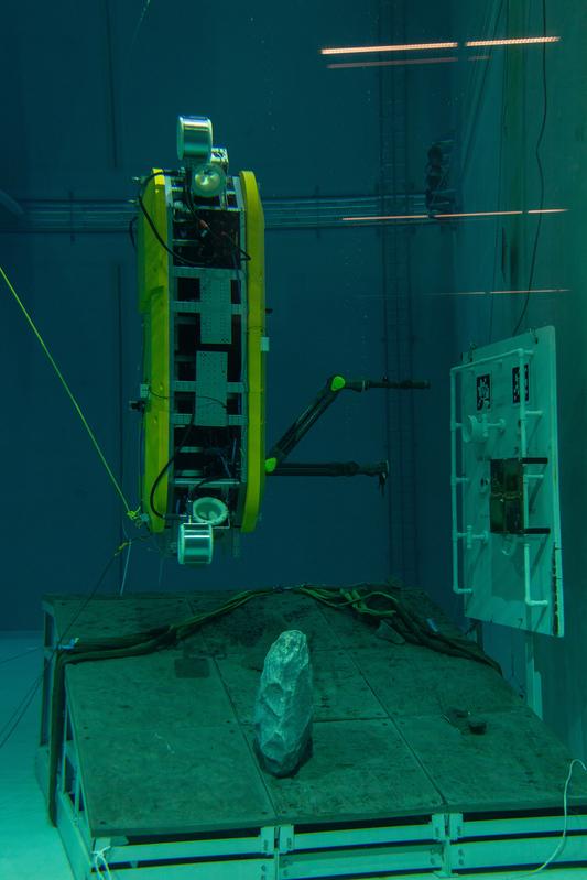 Das AUV führt in aufrechter Position Manipulationsaufgaben an einem Unterwasser-Mockup durch