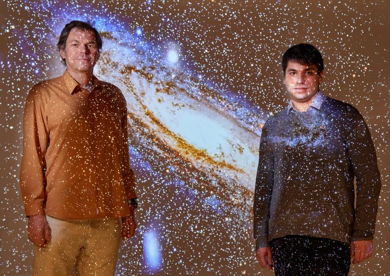 Prof. Dr. Pavel Kroupa (links) und Moritz Haslbauer (rechts) mit einer Projektion der Andromeda-Galaxie. 