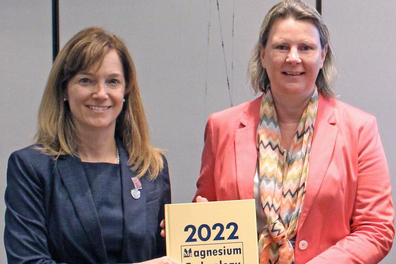 TMS-Präsidentin Ellen Cerreta (l.) überreicht Tagungsband „Magnesium Technology 2022“ an Prof. Dr. Petra Maier