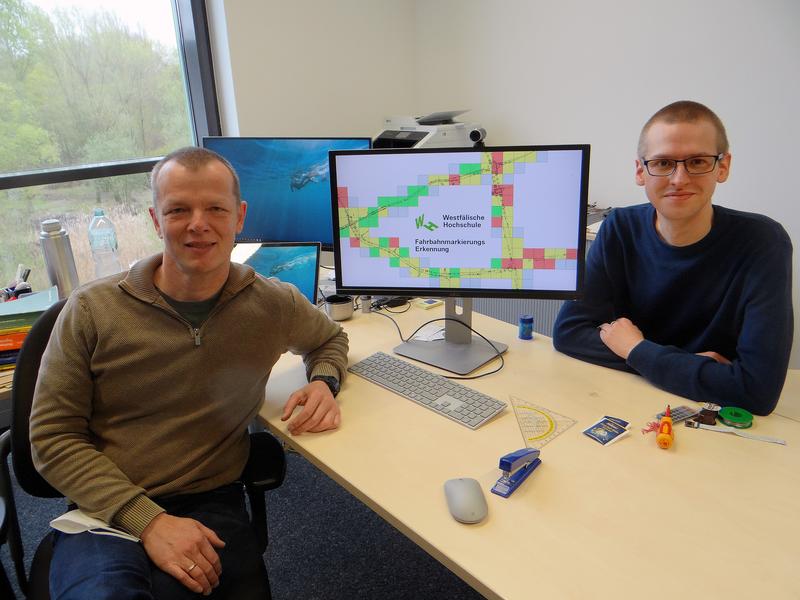 Prof. Dr. Christian Kuhlmann (links) und Alexander Roß (rechts) haben mit KI Fahrbahnmarkierungen analysiert und bezüglich eines möglichen Renovierungsbedarfs beurteilt. 