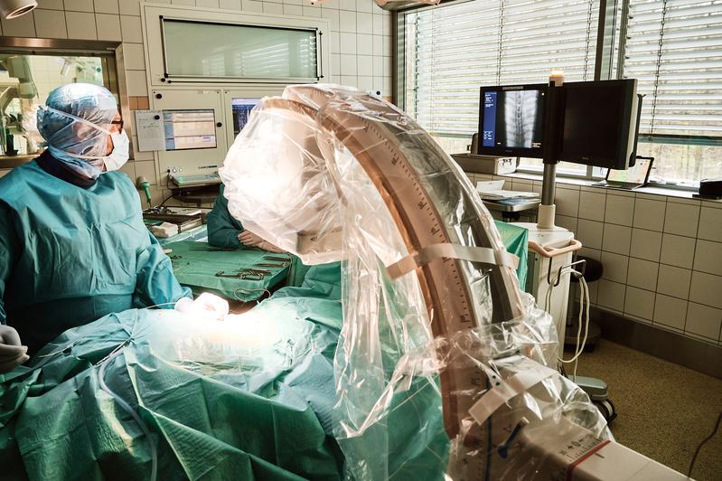 (v. l.) Prof. Jaroslaw Maciaczyk setzt das Implantat zur Neurostimulation eines Patienten mit Raynaud-Phänomen operativ ein