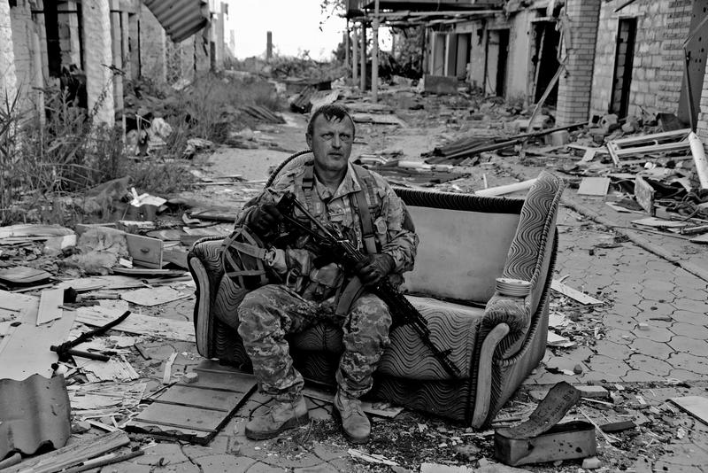 Wie eine Insel im Trümmermeer wirkt der Couchsessel, auf dem Soldat Vadym sitzt. Vor einigen Jahren hat er nicht weit entfernt eine Ferienwohnung für den Familienurlaub gemietet. Heute bleibt nichts als die Erinnerung - auch an Vadym.