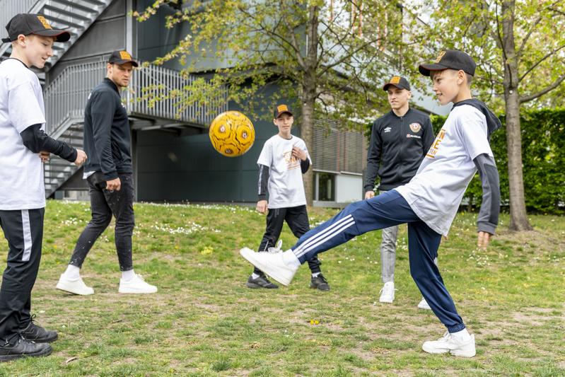 Sebastian Mai und Luca Herrmann von Dynamo Dresden kicken mit Schülern der Sportoberschule Dresden.