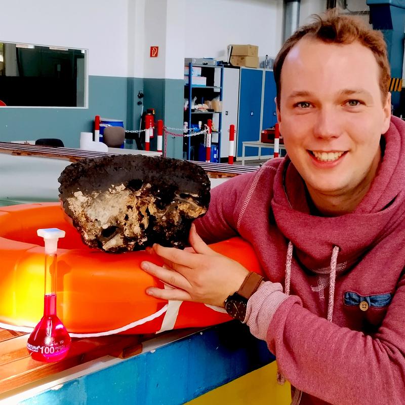 Researcher David Ernst with a deep-sea ferromanganese crust, a potential unconventional resource of critical high-technology metals.