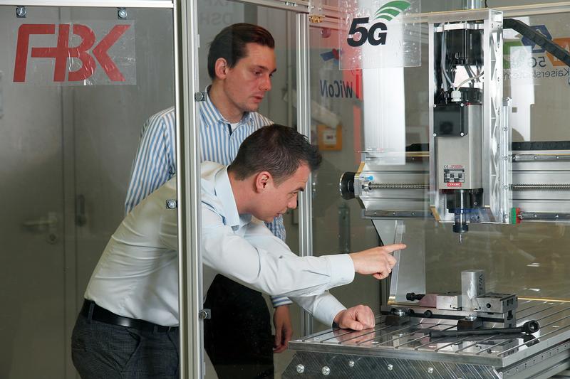 The team led by Jan Mertes (front) and Peter Simon developed a digital twin for this machine tool. Machine data and control commands are transmitted using 5G technology. 