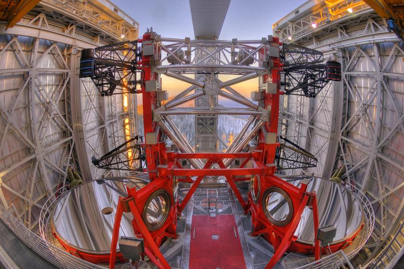 Blick aus dem Dom des Large Binocular Telescope (LBT) durch die geöffneten Kuppeltore. Im Vordergrund befinden sich die beiden großen Hauptspiegel mit der Tragestruktur für die Sekundärspiegel.