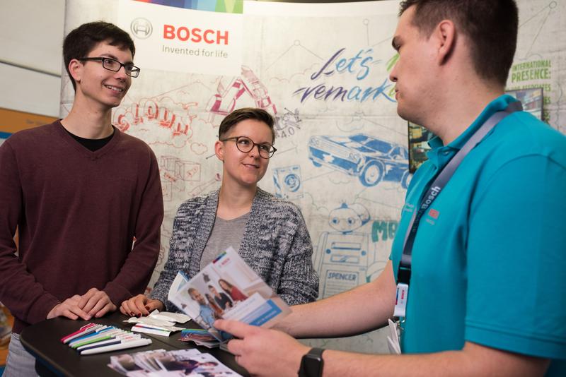 Besucher*innen und Aussteller der campus-X-change im Informationsgespräch am Messestand.