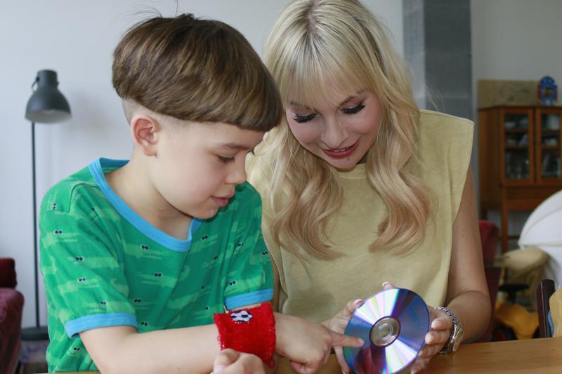 Susanne Klehn, Botschafterin für Hautkrebsprävention der Deutschen Krebshilfe, und Jonathan (7 Jahre) experimentieren mit den Spektralfarben des Sonnenlichts.